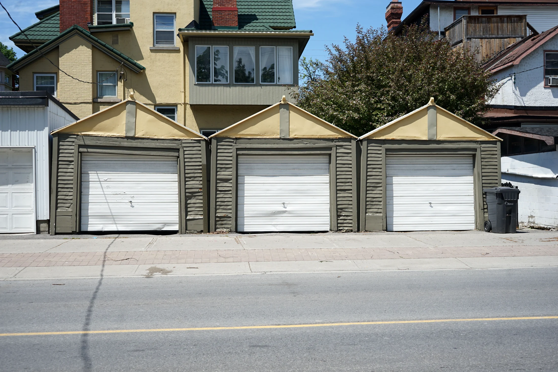 A row of older garage doors, including a visibly dented door