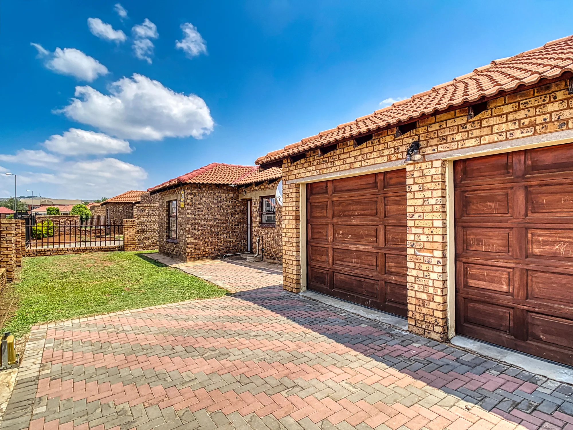Brick home with two garage doors and a paved driveway