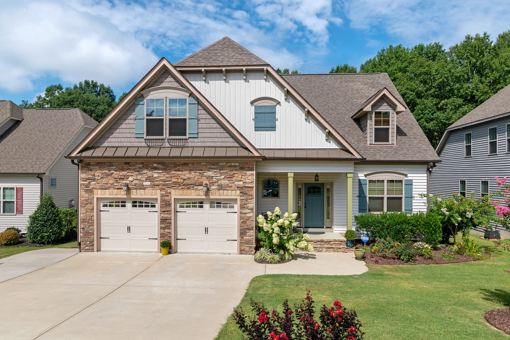 A light-colored home with new double garage doors