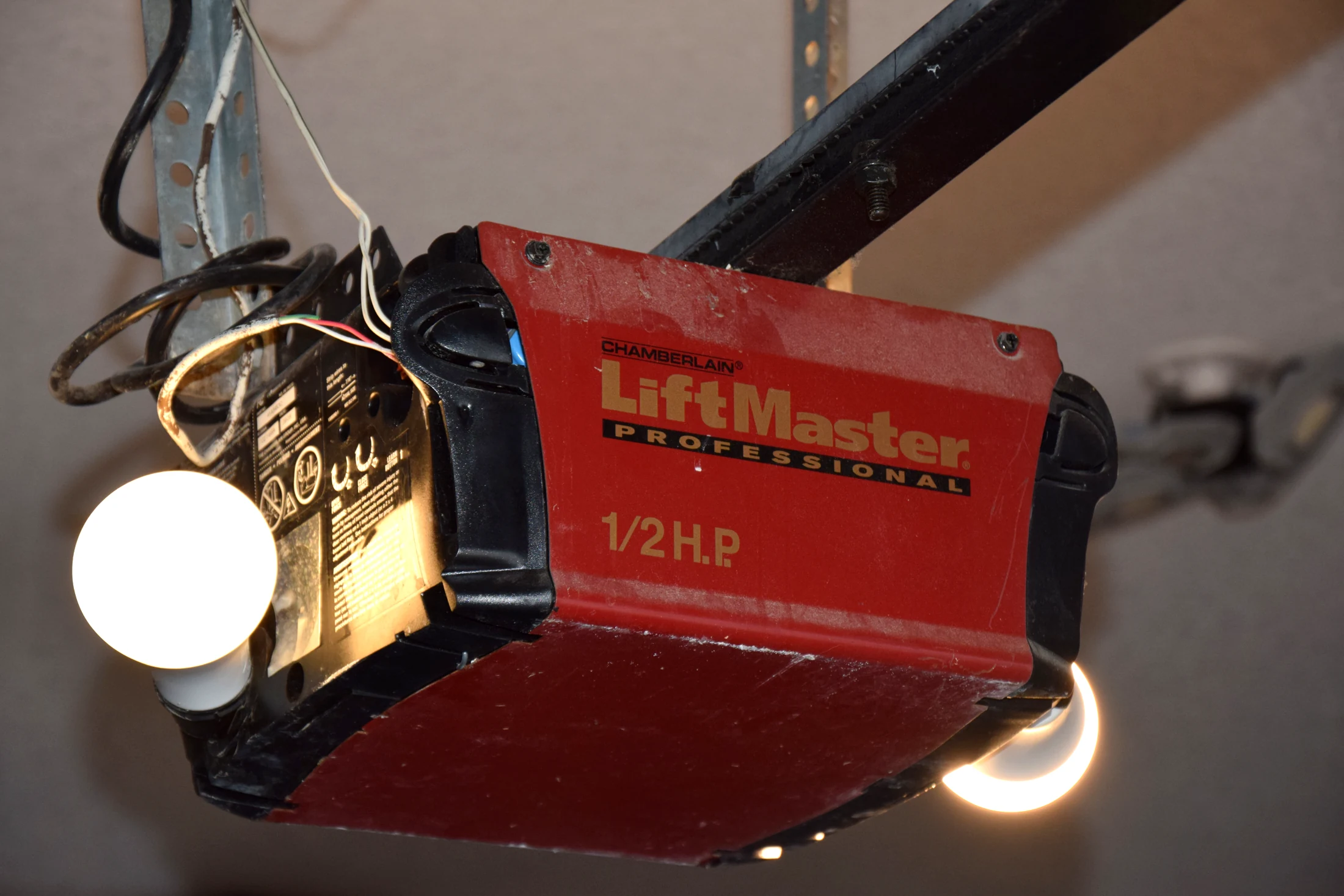 A ceiling-mounted chain-drive garage door opener and light